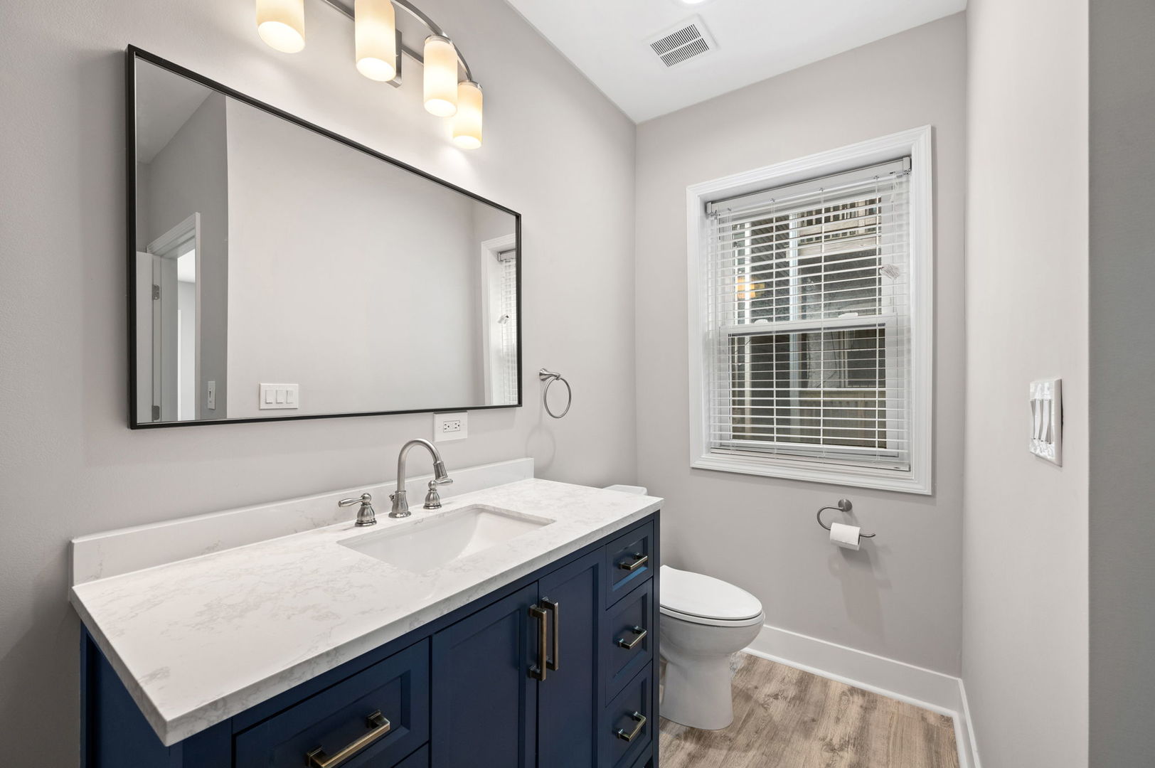 2756 West Monroe Street Chicago, IL 60612 - Photo 31 of 52 a bathroom with a granite countertop toilet a sink a mirror and a window