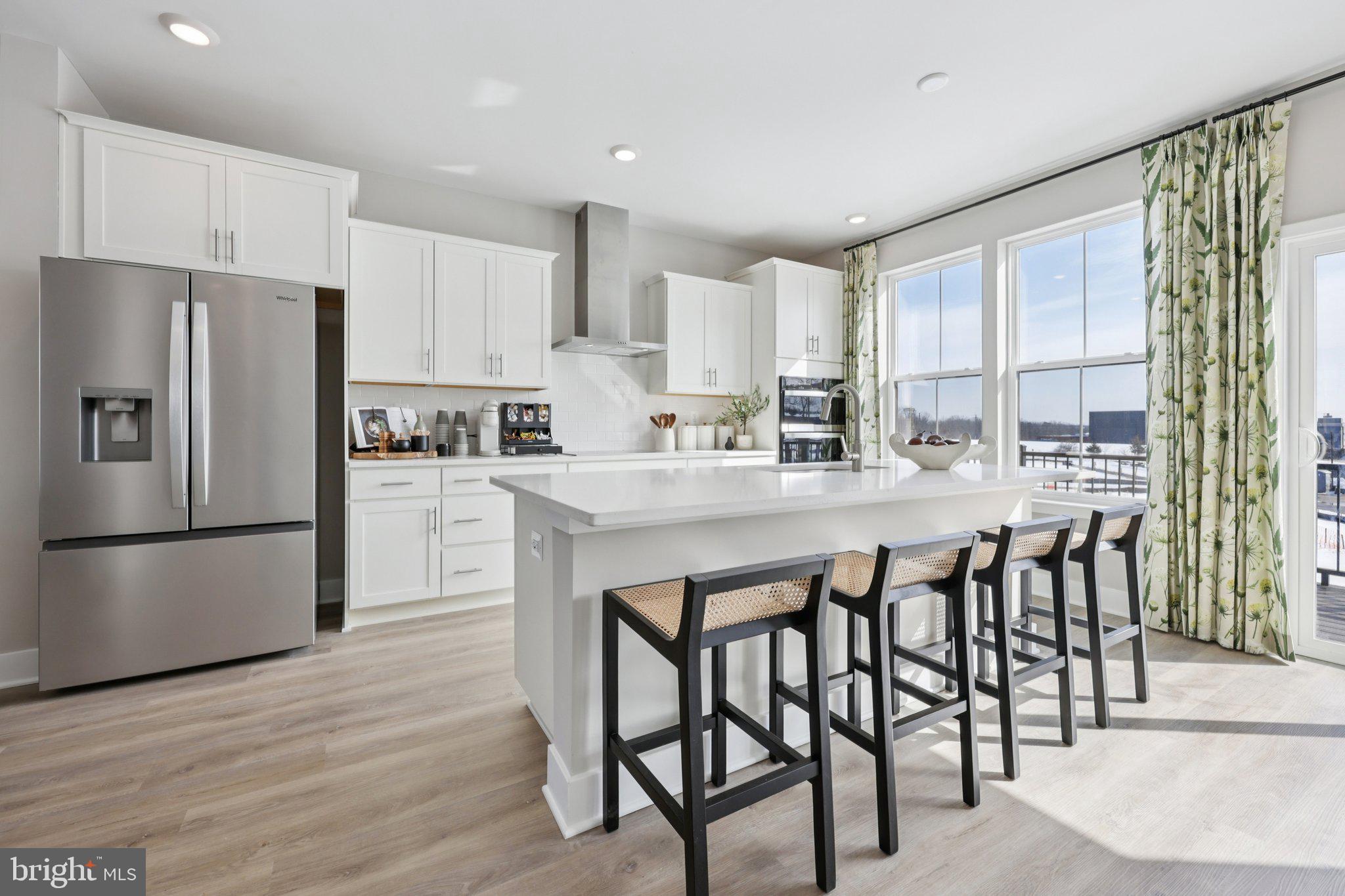 11361 Hypatia Loop Manassas, VA 20110 - Photo 13 of 55 a kitchen with stainless steel appliances granite countertop a refrigerator a stove a sink dishwasher and white cabinets with wooden floor