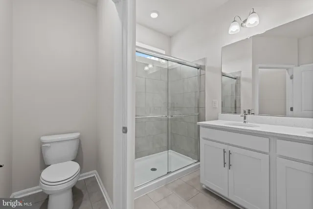 a bathroom with a shower sink vanity and toilet