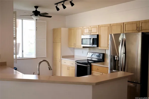 a kitchen with stainless steel appliances granite countertop a refrigerator a stove a sink and a microwave