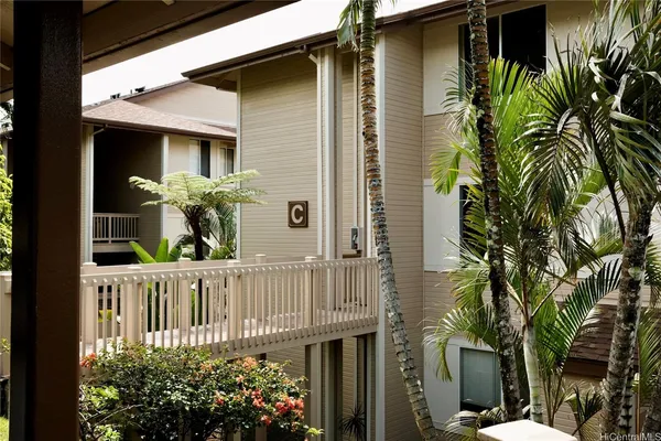 a view of a house with a small yard and flower plants