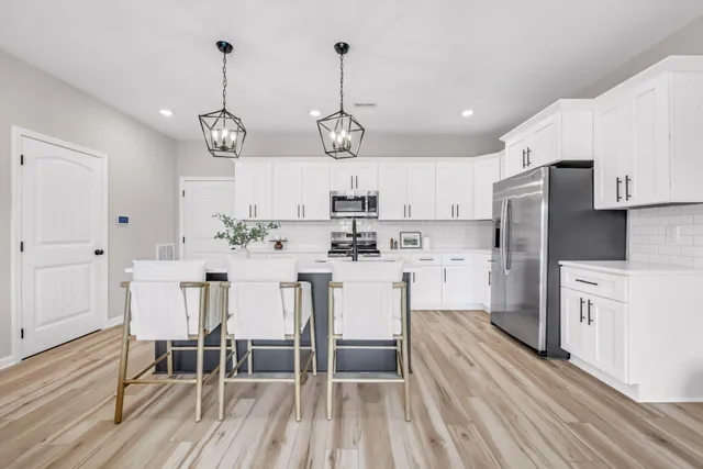 a kitchen with white cabinets stainless steel appliances and kitchen island