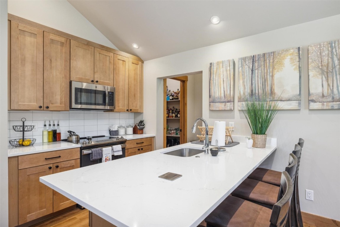 41 Barton Ridge Drive Breckenridge, CO 80424 - Photo 36 of 42 a kitchen with stainless steel appliances a sink a microwave a refrigerator and cabinets