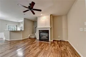 a view of empty room with wooden floor and fireplace