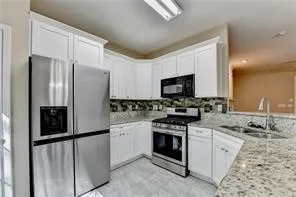 a kitchen with stainless steel appliances granite countertop a refrigerator stove and sink