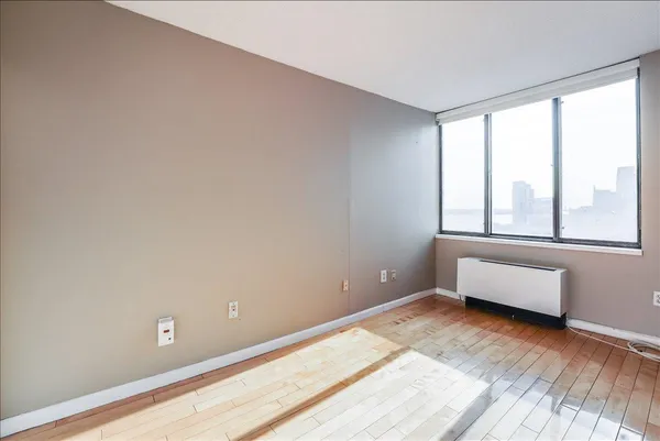 a view of room with window and wooden floor