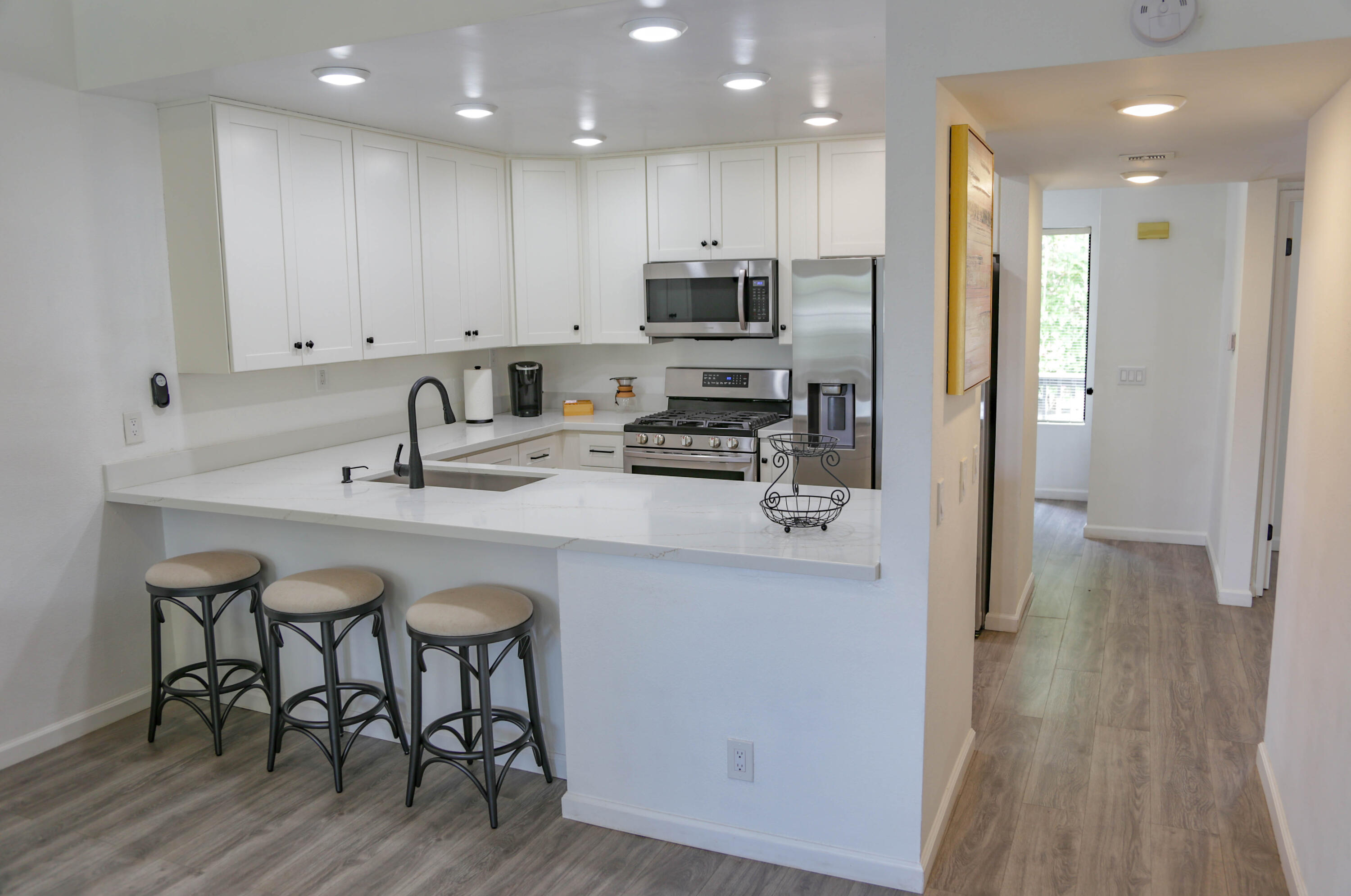 325 Ladera Street, Unit 5 Santa Barbara, CA 93101 - Photo 8 of 16 a kitchen with kitchen island granite countertop a sink and stainless steel appliances