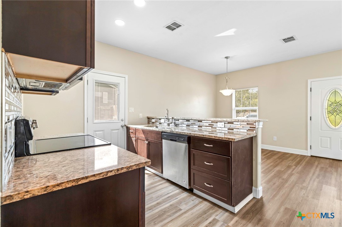 1628 Armstrong Street Luling, TX 78648 - Photo 11 of 23 a kitchen with granite countertop a sink and a stove top oven
