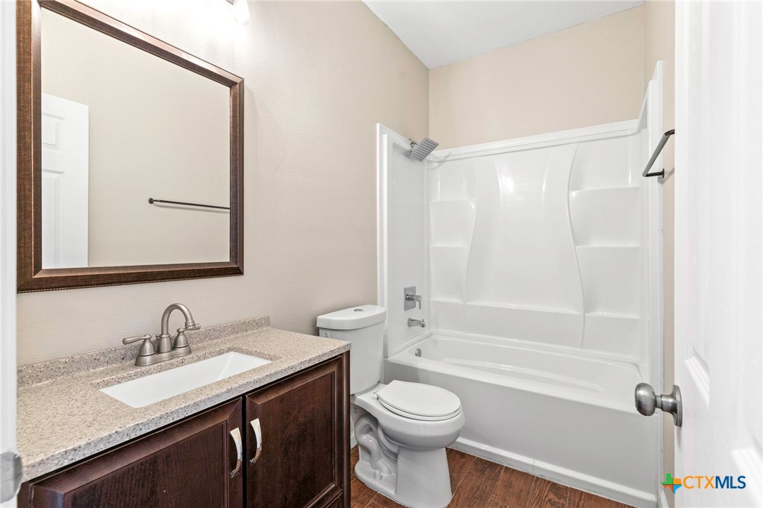 1628 Armstrong Street Luling, TX 78648 - Photo 13 of 23 a bathroom with a granite countertop sink toilet and shower