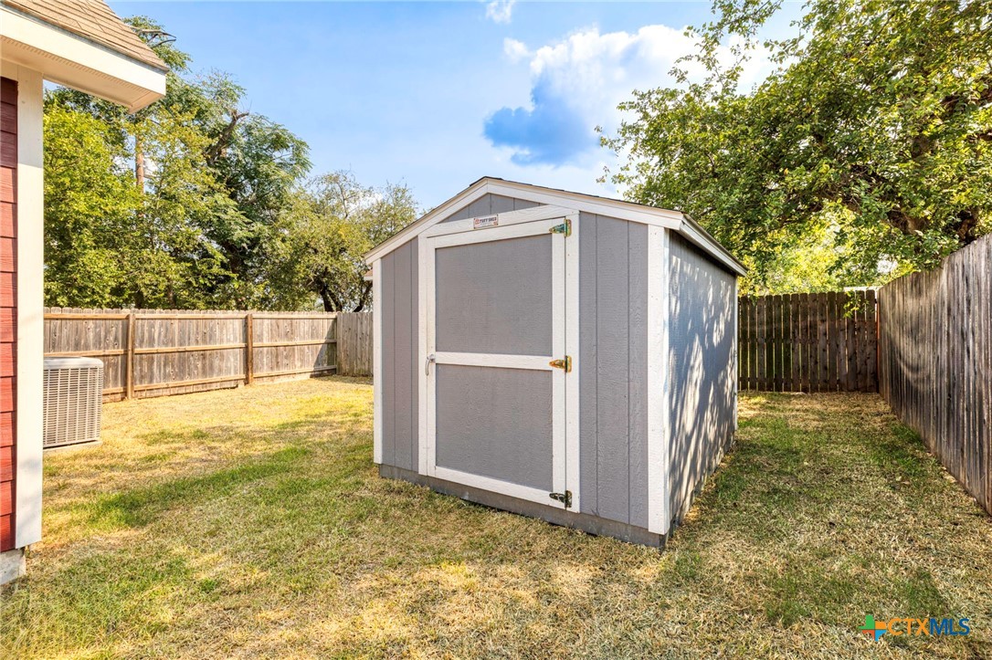 1628 Armstrong Street Luling, TX 78648 - Photo 22 of 23 a view of a small space in front of a house with wooden fence and large trees