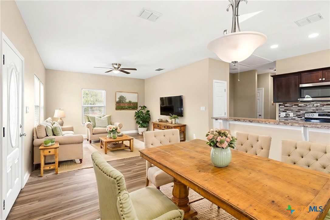 1628 Armstrong Street Luling, TX 78648 - Photo 7 of 23 a living room with kitchen island furniture and a flat screen tv