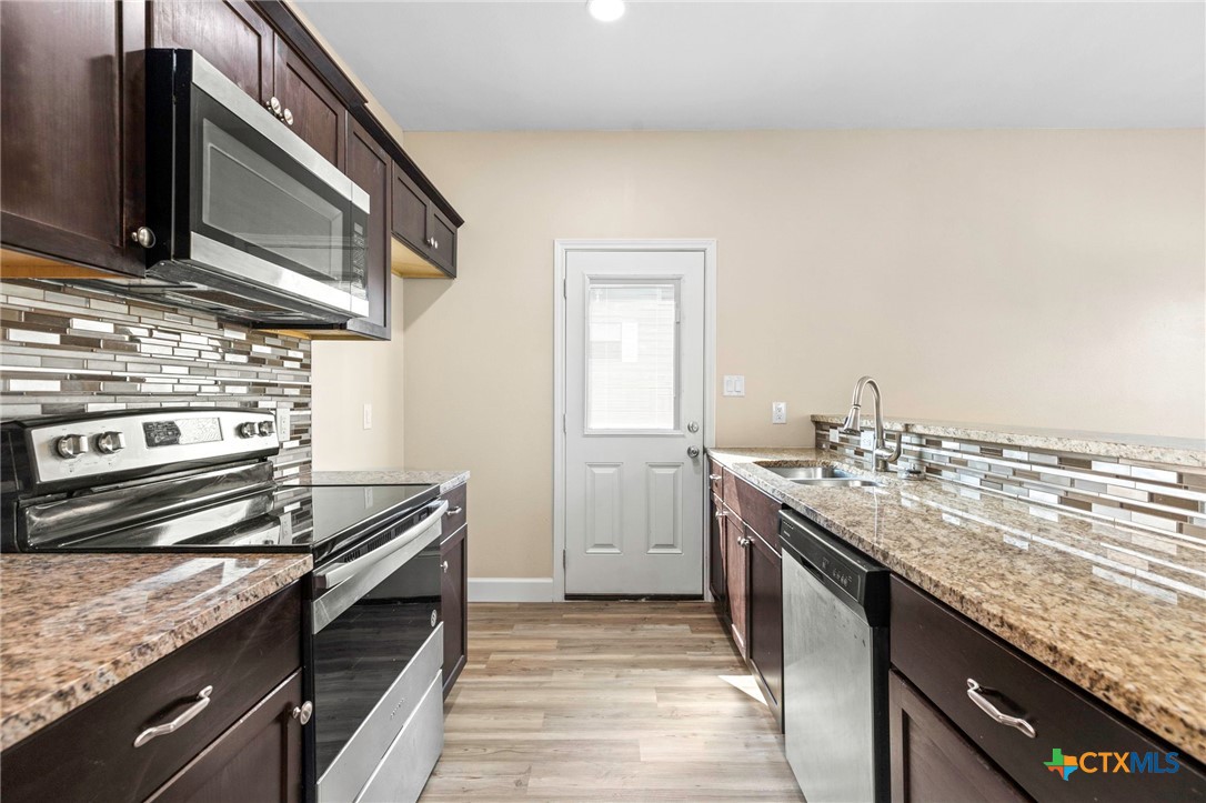 1628 Armstrong Street Luling, TX 78648 - Photo 10 of 23 a kitchen with a stove and a sink