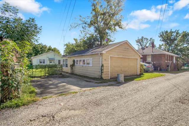 a view of a house with backyard and a tree