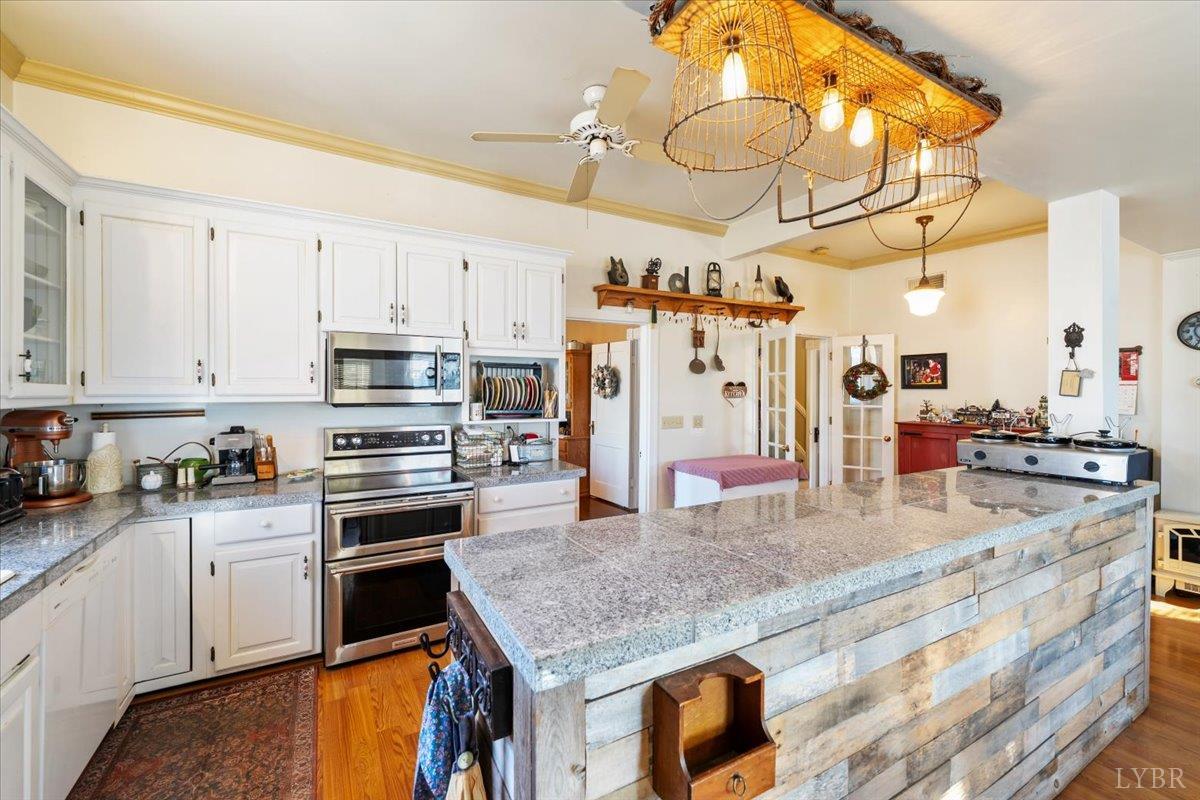 601 Henry Street Gretna, VA 24557 - Photo 11 of 46 a kitchen with stainless steel appliances granite countertop a sink a stove and cabinets