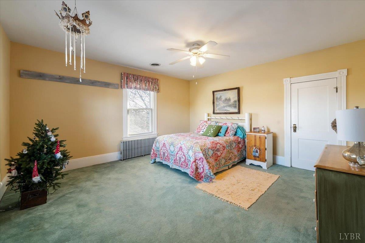 601 Henry Street Gretna, VA 24557 - Photo 29 of 46 a bedroom with a bed and a chandelier