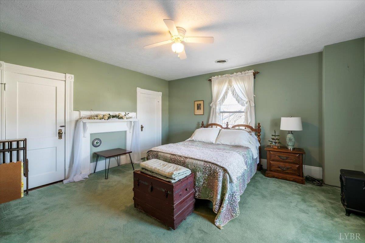 601 Henry Street Gretna, VA 24557 - Photo 31 of 46 a spacious bedroom with a bed and a chandelier