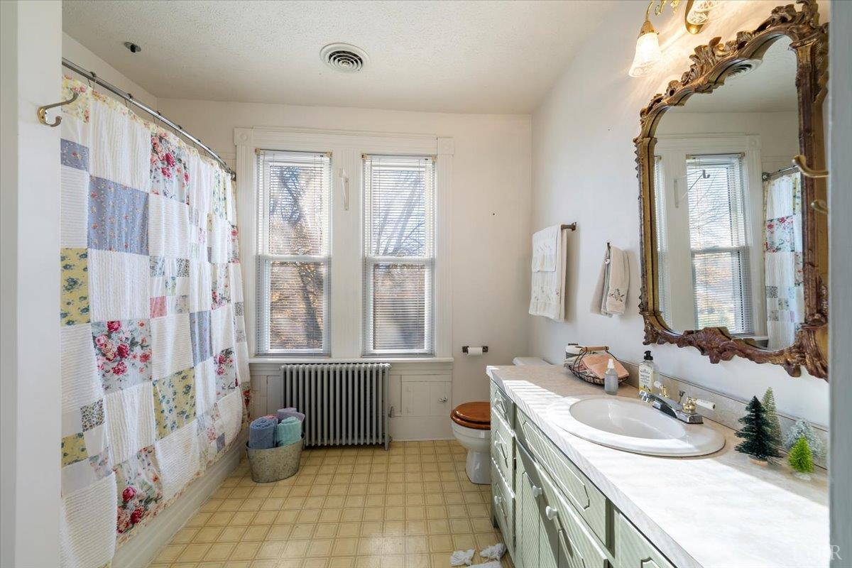 601 Henry Street Gretna, VA 24557 - Photo 32 of 46 a bathroom with a sink a toilet and a large mirror