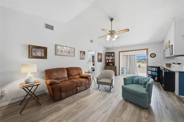 a living room with furniture and a ceiling fan