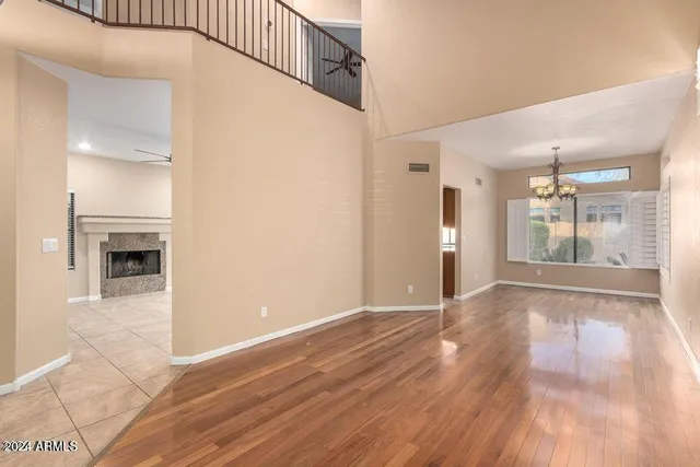a view of an empty room with kitchen and a window
