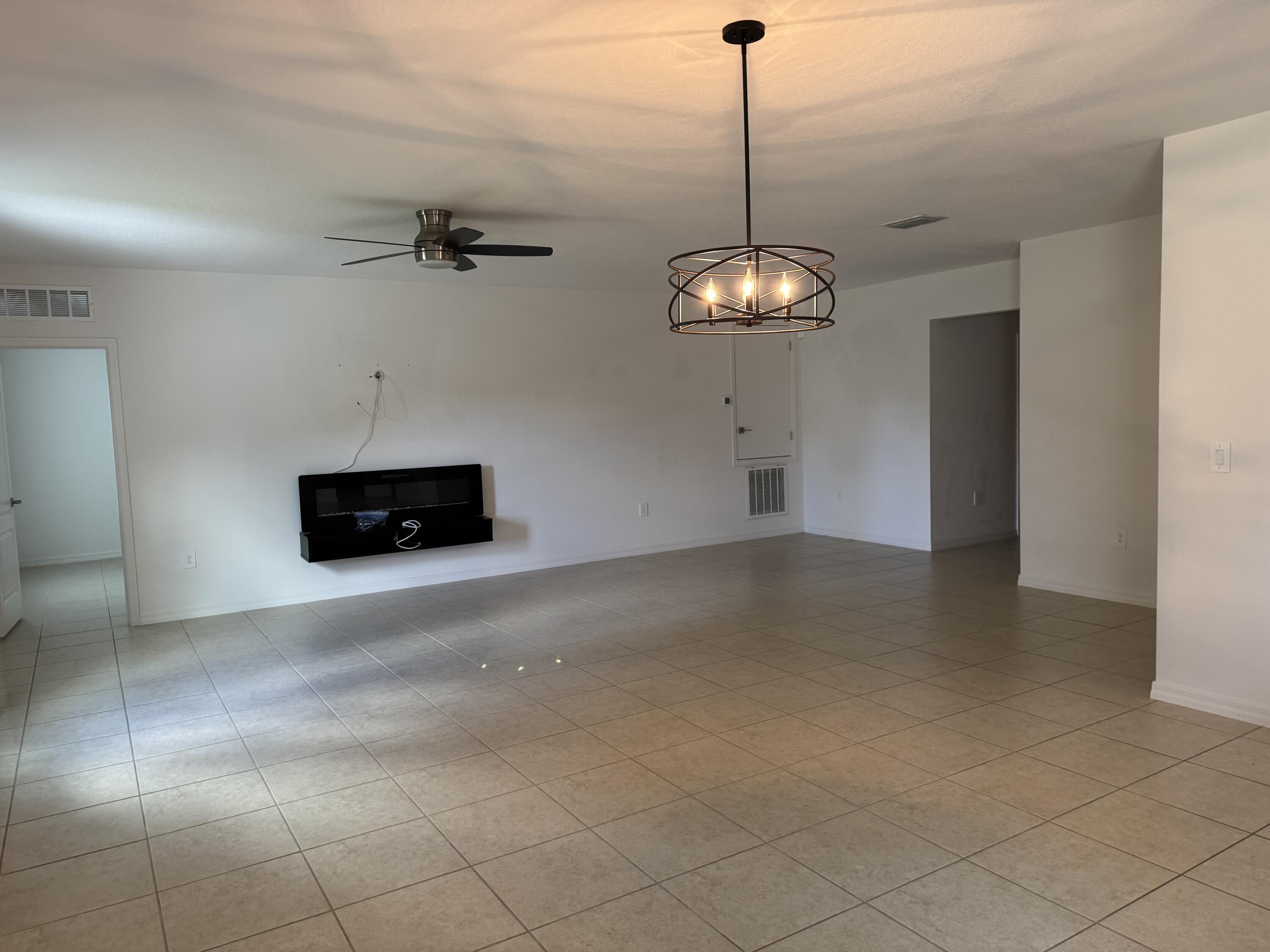 3725 Southwest Kasin Street Port St. Lucie, FL 34953 - Photo 4 of 18 a view of a livingroom and a chandelier fan