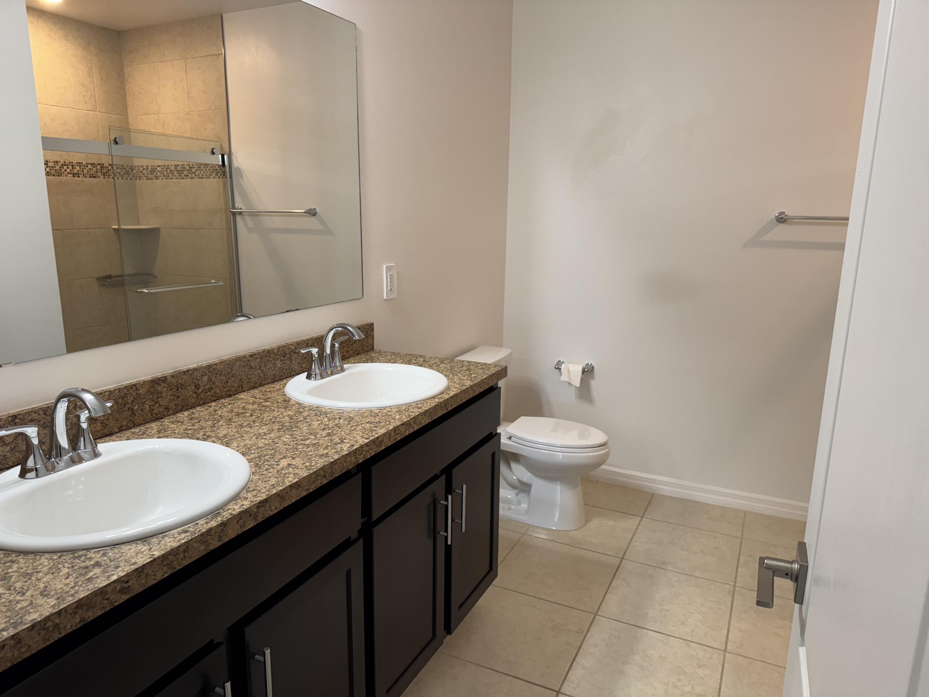 3725 Southwest Kasin Street Port St. Lucie, FL 34953 - Photo 8 of 18 a bathroom with a granite countertop sink and a toilet
