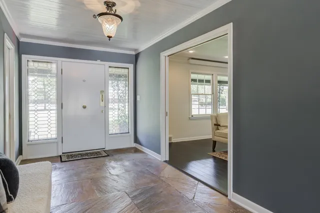 a view of a dining room with furniture a chandelier and wooden floor