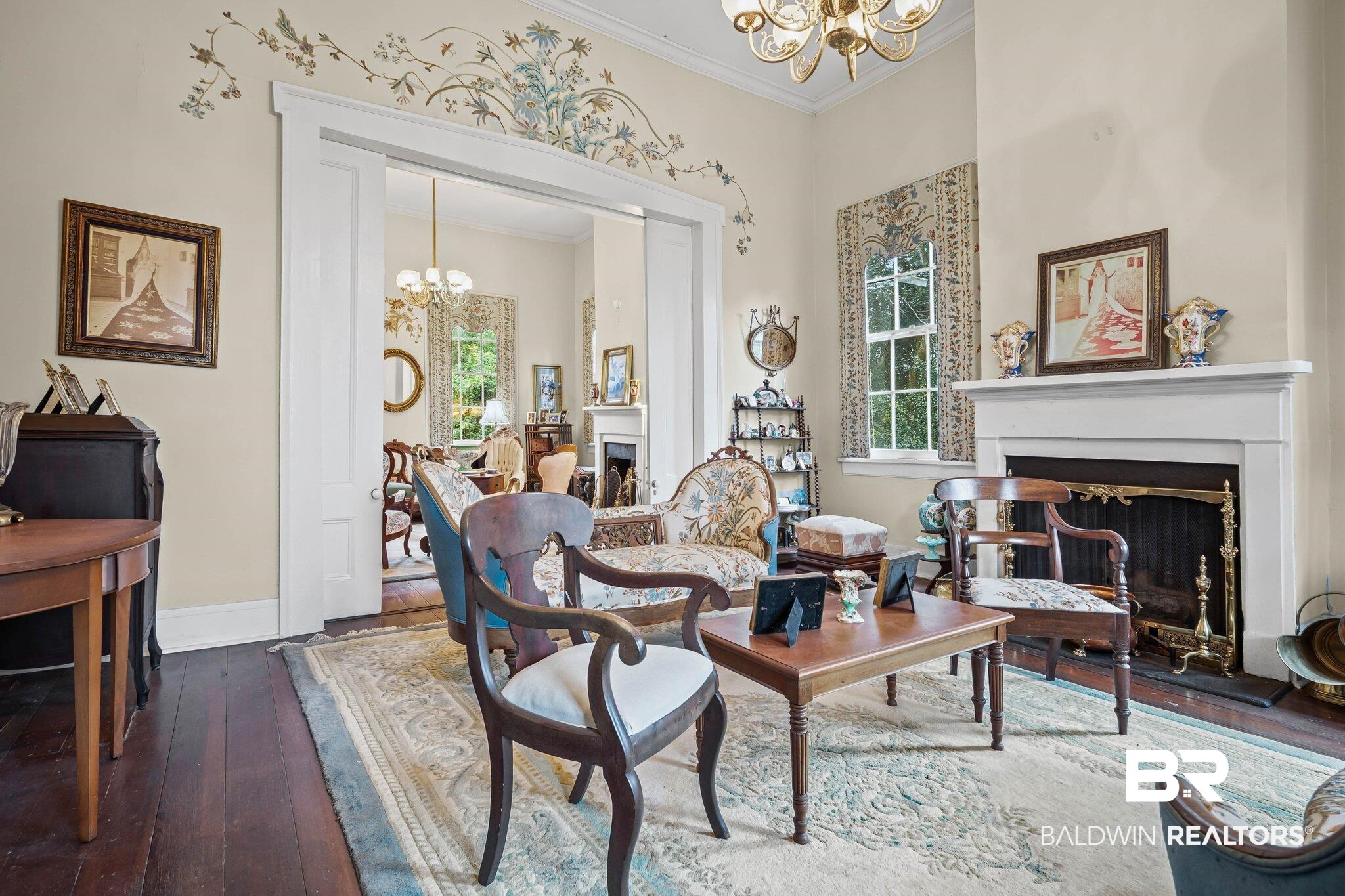 23561 Main Street Fairhope, AL 36532 - Photo 13 of 45 Living area featuring a fireplace, a chandelier, ornamental molding, and dark wood finished floors