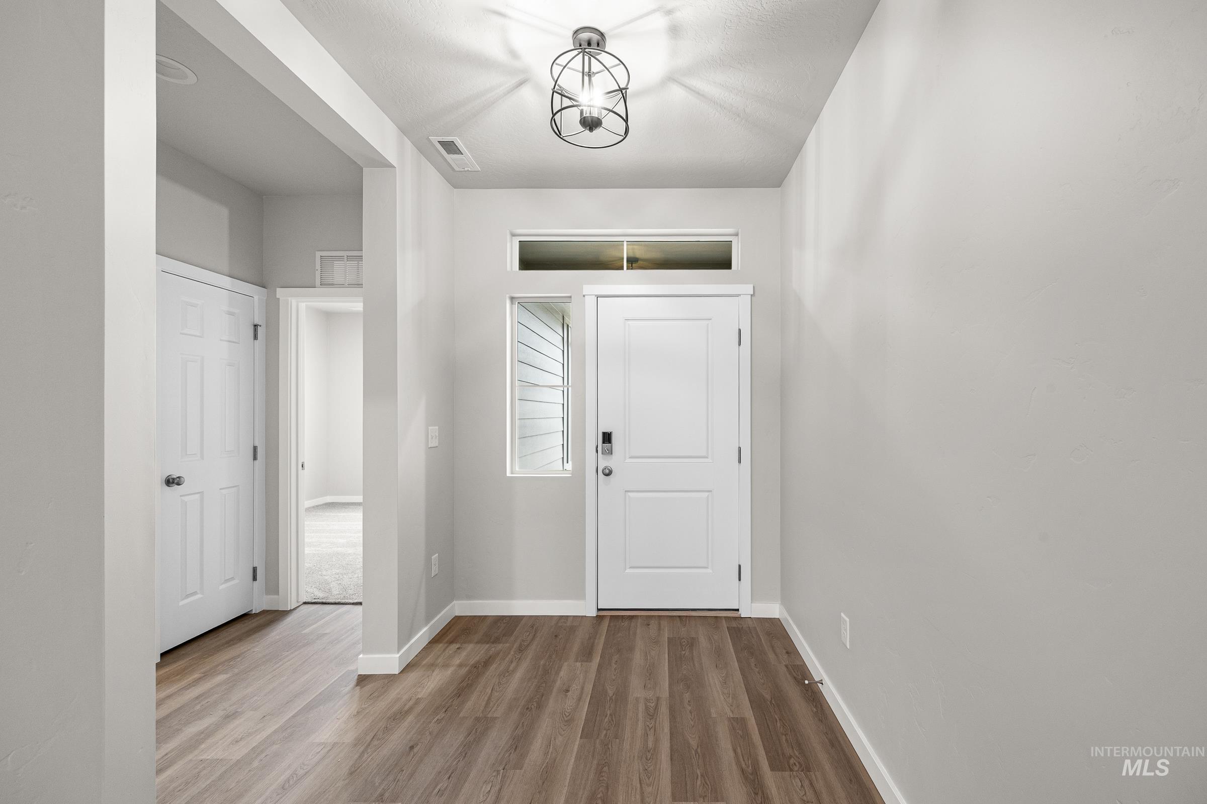 13656 Redway Court Caldwell, ID 83607 - Photo 2 of 21 Entryway featuring wood-finish flooring, a white paneled door with smart lock, and an overhead transom window