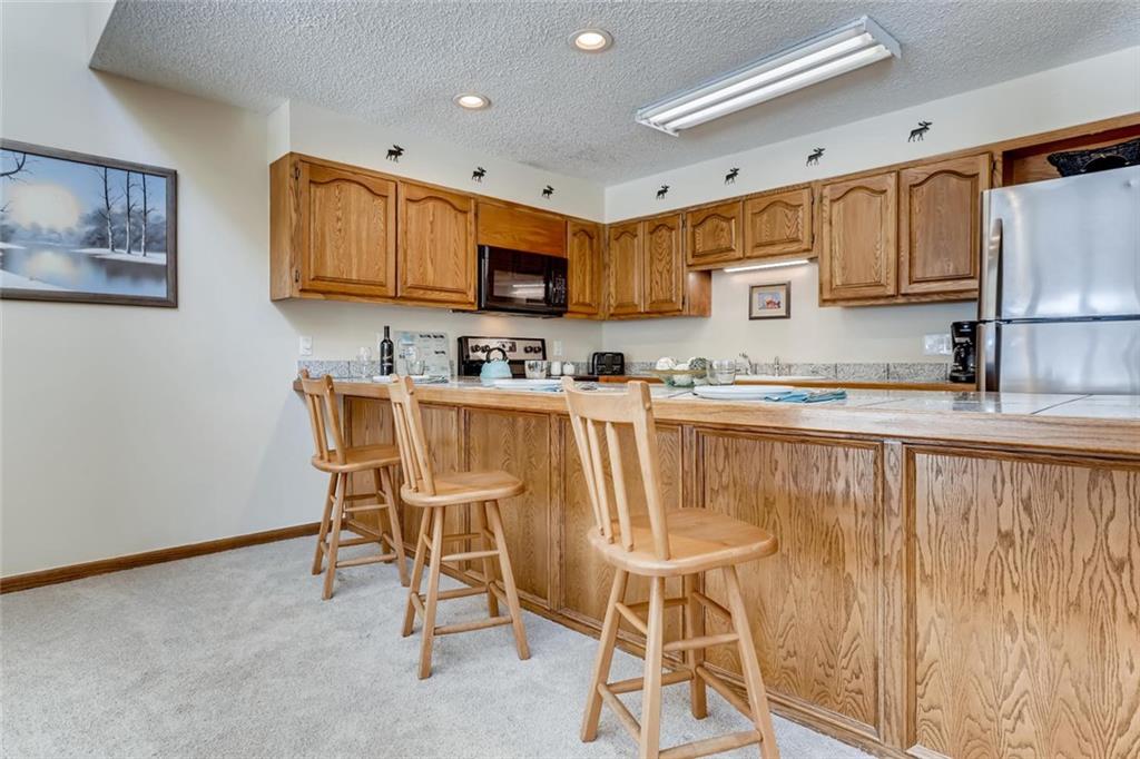 760 Copper Road, Unit 201 Copper Mountain, CO 80443 - Photo 12 of 28 a kitchen with stainless steel appliances granite countertop a stove a sink dishwasher and a refrigerator