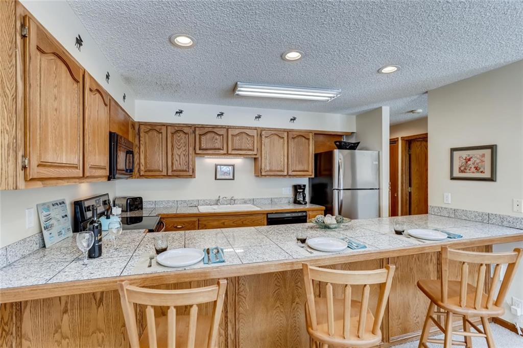 760 Copper Road, Unit 201 Copper Mountain, CO 80443 - Photo 9 of 28 a kitchen with stainless steel appliances granite countertop a sink stove and refrigerator