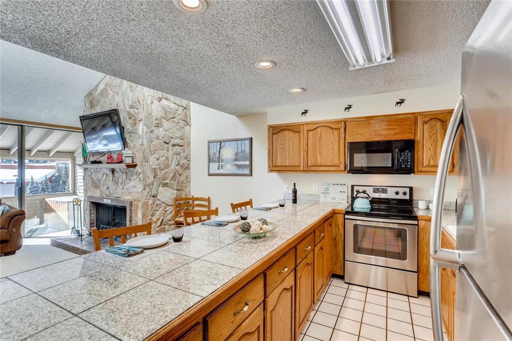 760 Copper Road, Unit 201 Copper Mountain, CO 80443 - Photo 10 of 28 a kitchen with stainless steel appliances a stove a sink and a microwave