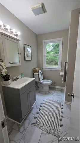 a spacious bathroom with a double vanity sink a mirror and a toilet