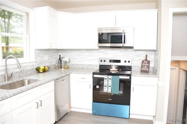 a kitchen with stainless steel appliances granite countertop a sink stove and microwave