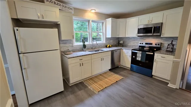 a kitchen with appliances a sink and a refrigerator