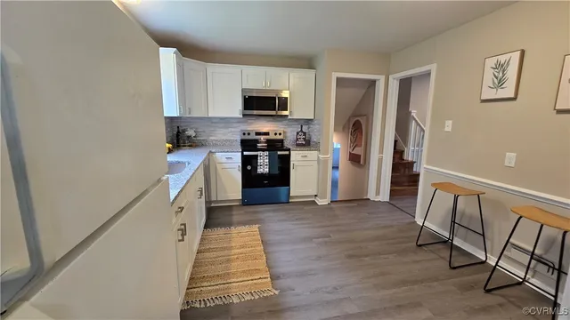 a kitchen with granite countertop a refrigerator and a sink
