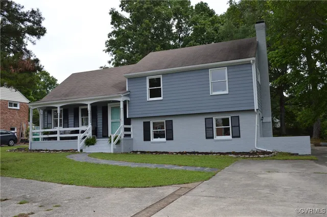 a front view of a house with a garden and trees