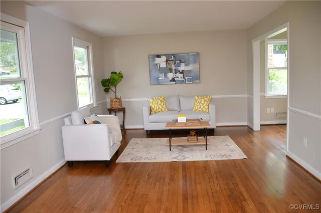a living room with furniture and a wooden floor
