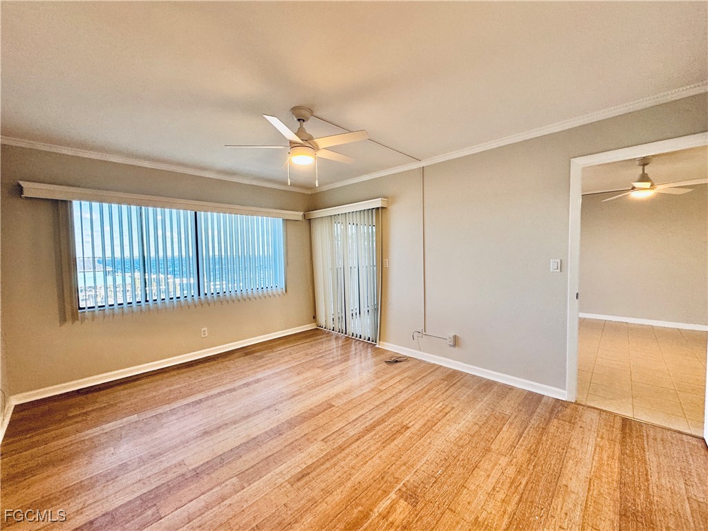 2711 First Street, Unit 102 Fort Myers, FL 33916 - Photo 12 of 36 a view of an empty room with wooden floor and a window