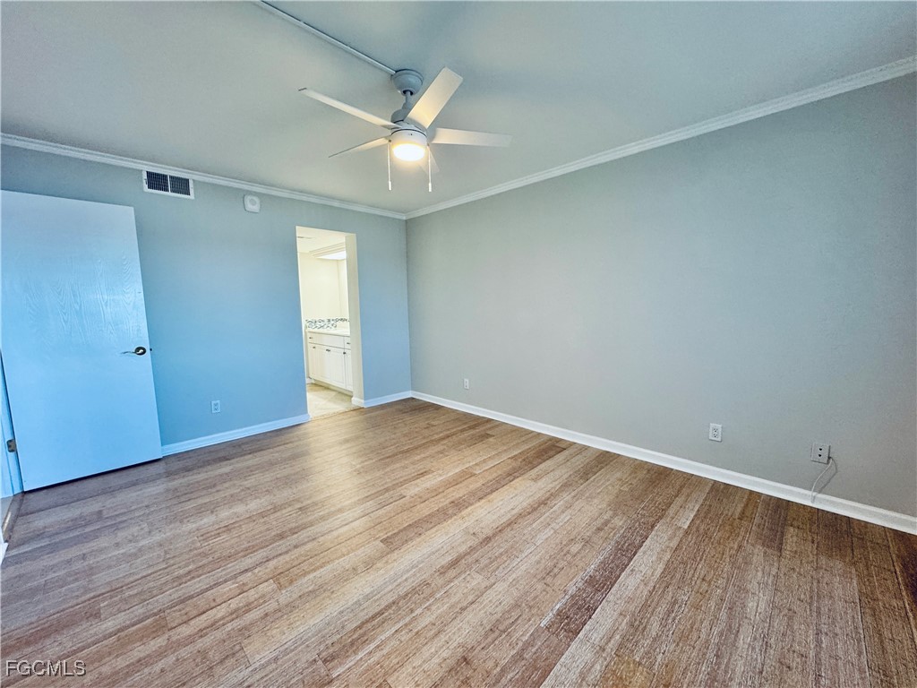 2711 First Street, Unit 102 Fort Myers, FL 33916 - Photo 14 of 36 a view of an empty room with wooden floor and a window