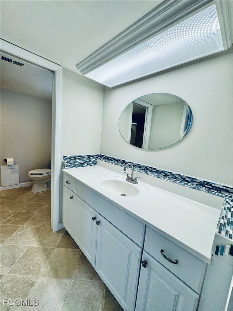 2711 First Street, Unit 102 Fort Myers, FL 33916 - Photo 16 of 36 a bathroom with a toilet sink and mirror