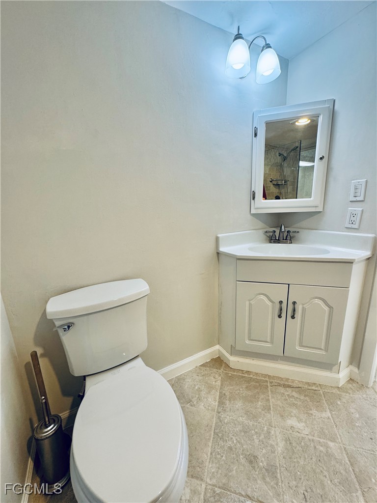 2711 First Street, Unit 102 Fort Myers, FL 33916 - Photo 18 of 36 a bathroom with a toilet sink and mirror