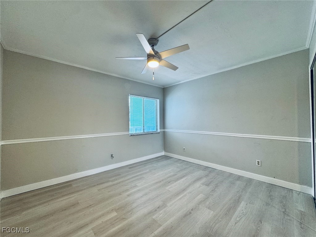 2711 First Street, Unit 102 Fort Myers, FL 33916 - Photo 23 of 36 an empty room with a window and ceiling fan