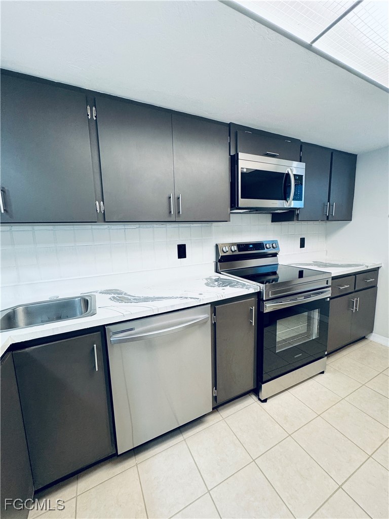 2711 First Street, Unit 102 Fort Myers, FL 33916 - Photo 7 of 36 a kitchen with stainless steel appliances granite countertop a sink and a stove