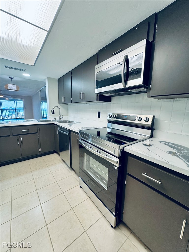 2711 First Street, Unit 102 Fort Myers, FL 33916 - Photo 8 of 36 a kitchen with stainless steel appliances granite countertop a sink and a stove