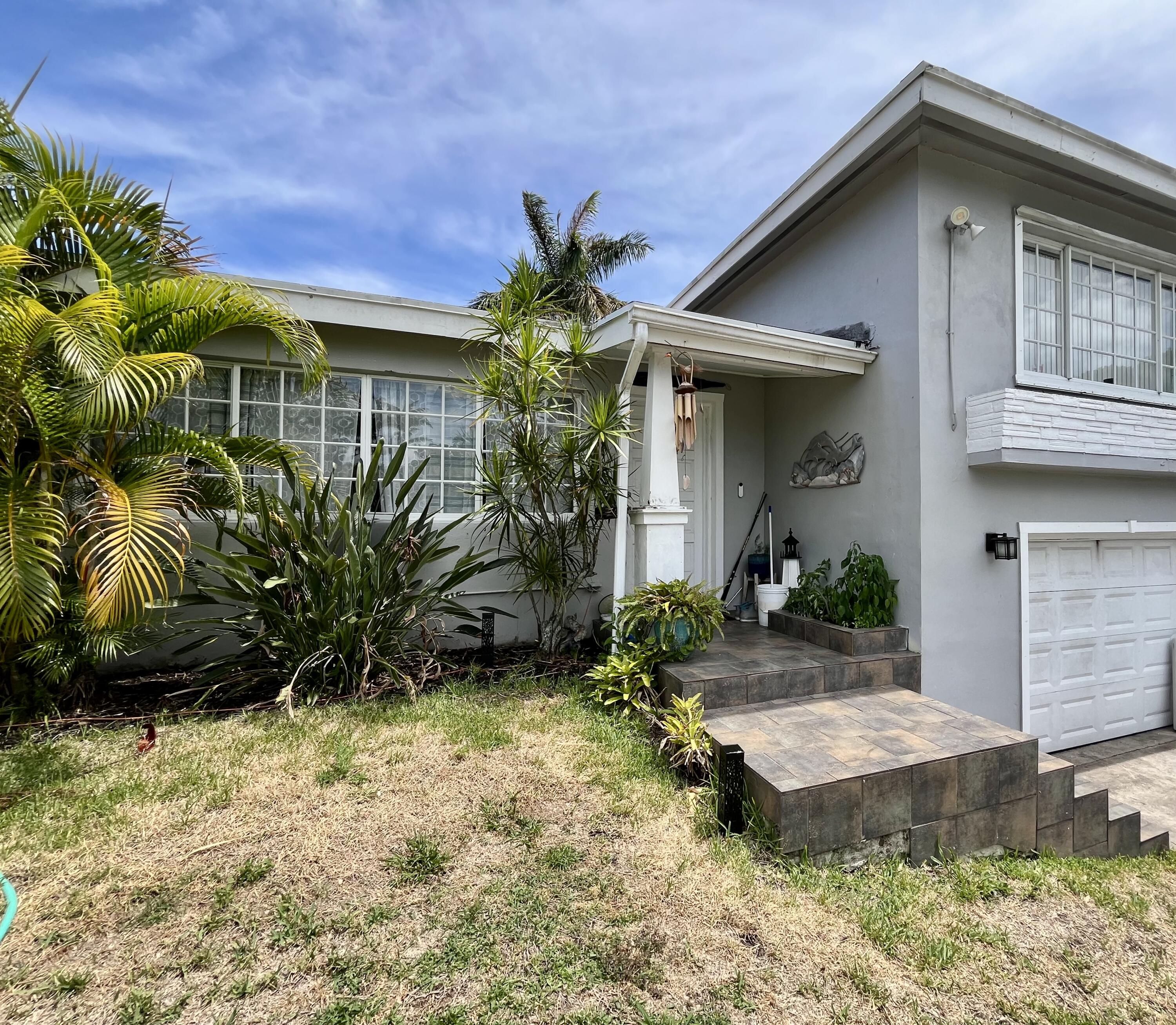 1424 Crest Drive Lake Worth, FL 33461 - Photo 5 of 16 a front view of a house with a yard