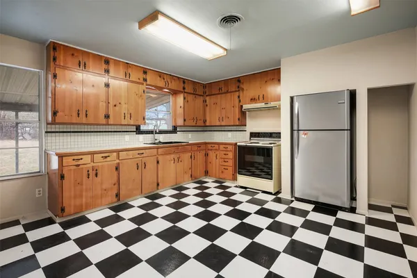 a kitchen with a checkered floor and white cabinets