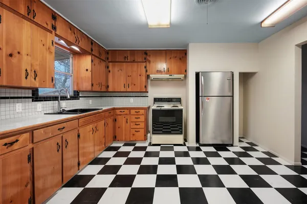 a kitchen with a checkered floor and white cabinets