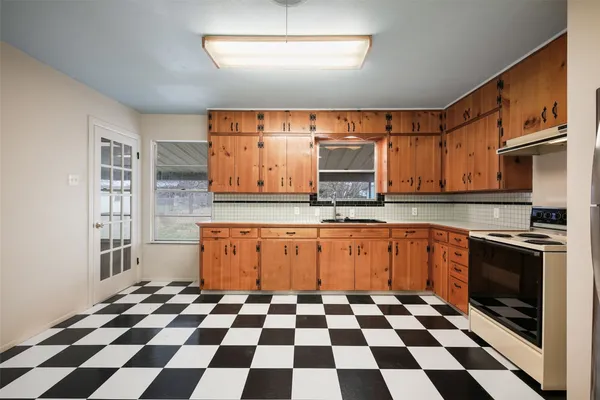 a kitchen with granite countertop stainless steel appliances a sink and cabinets