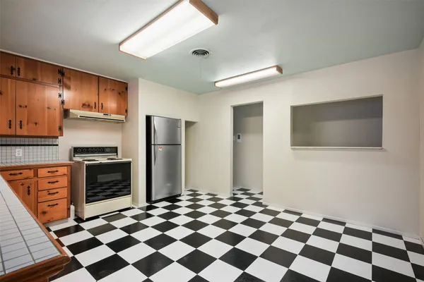 a kitchen with stainless steel appliances granite countertop a refrigerator and a stove top oven