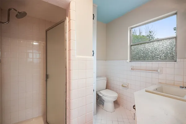a white toilet sitting next to a bathroom sink